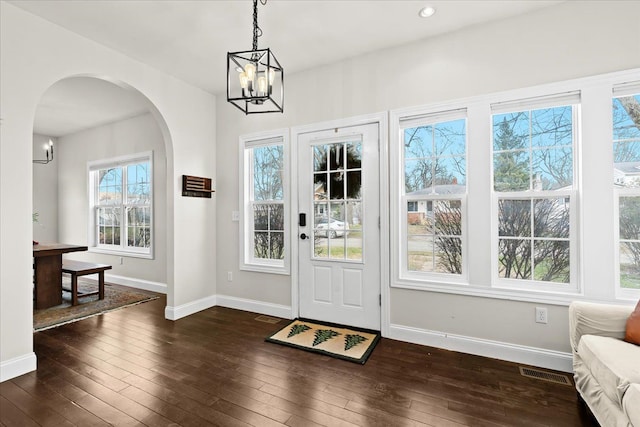 foyer featuring an inviting chandelier and dark hardwood / wood-style floors