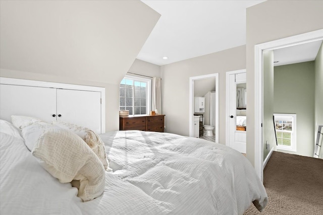 carpeted bedroom with lofted ceiling, multiple windows, a closet, and connected bathroom