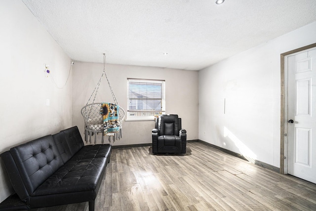 sitting room featuring a textured ceiling and light wood-type flooring