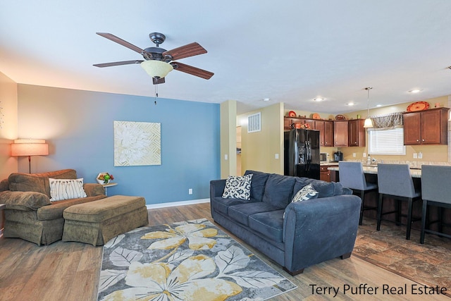 living room featuring dark hardwood / wood-style flooring and ceiling fan