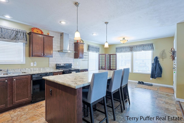 kitchen with a textured ceiling, wall chimney range hood, black appliances, and a center island