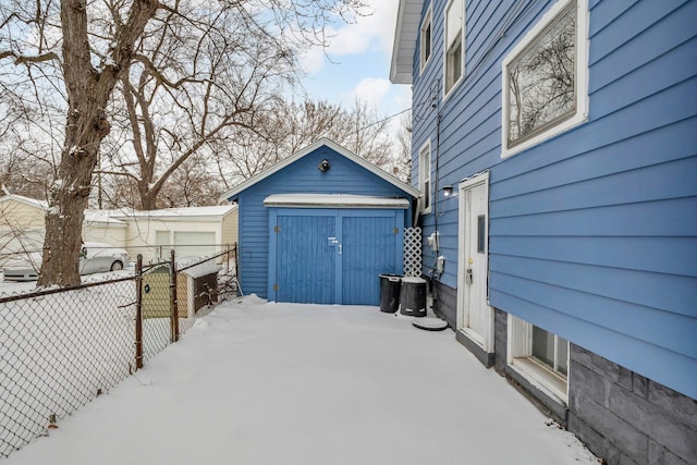 snow covered patio featuring a storage shed