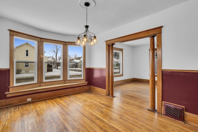 unfurnished room featuring light wood-type flooring and an inviting chandelier