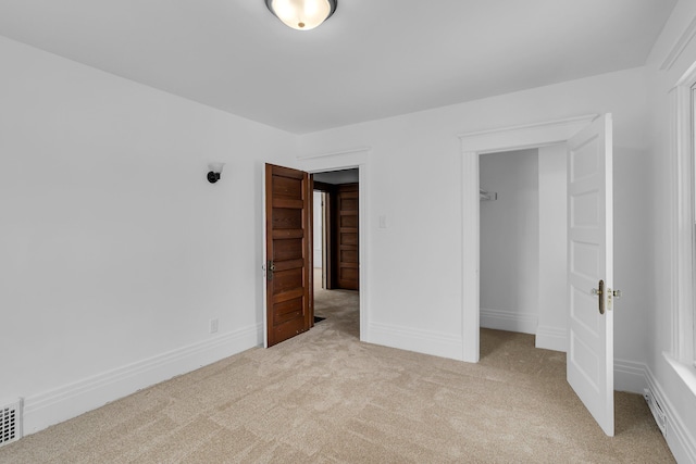 unfurnished bedroom featuring a closet and light carpet