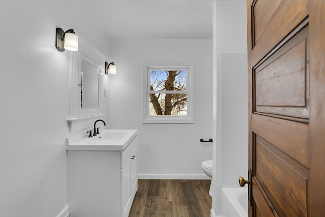 bathroom featuring toilet, hardwood / wood-style flooring, and vanity