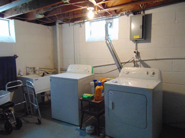 laundry room with electric panel, separate washer and dryer, a wealth of natural light, and sink