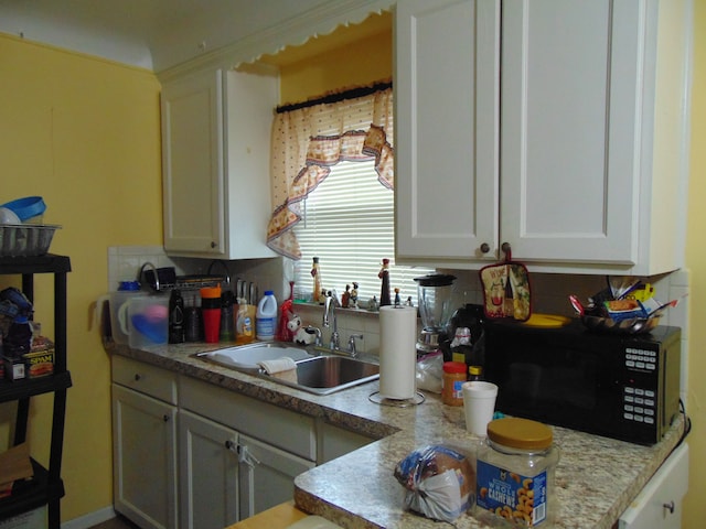 kitchen with sink, white cabinets, and tasteful backsplash