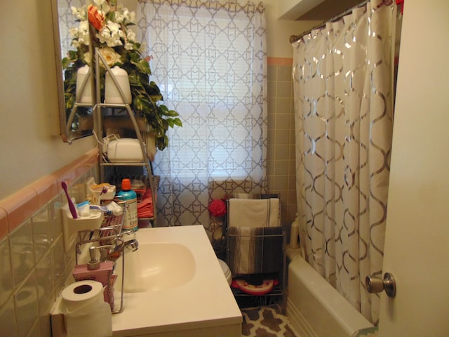 bathroom with sink, tile walls, and shower / bath combo