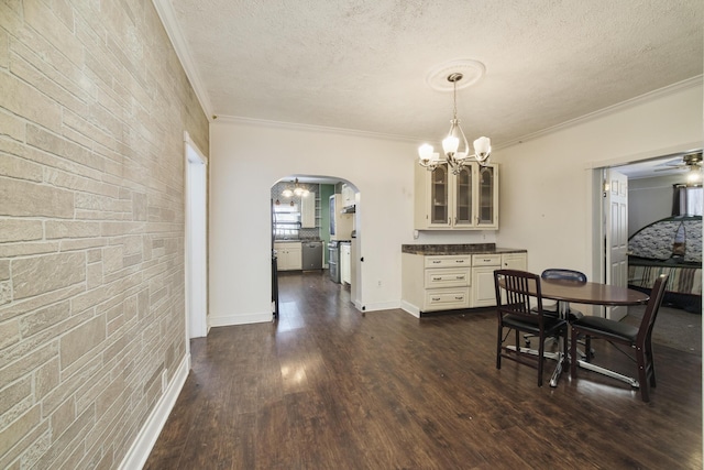 416 S Michigan Ave, Manton, MI 49663 - dining space with a chandelier, arched walkways, ornamental molding, a textured ceiling, and dark wood-style flooring