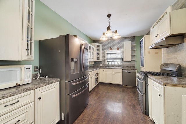 416 S Michigan Ave, Manton, MI 49663 - kitchen featuring appliances with stainless steel finishes, a sink, dark wood-style flooring, under cabinet range hood, and dark countertops