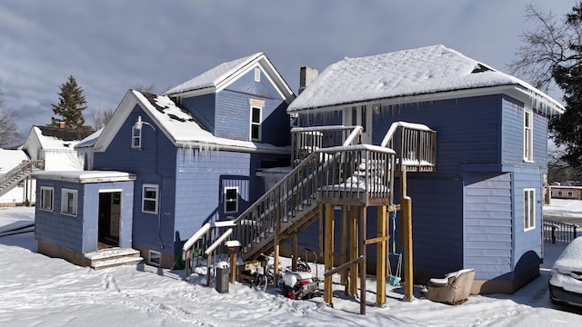 416 S Michigan Ave, Manton, MI 49663 - snow covered property with stairs, a chimney, and a garage