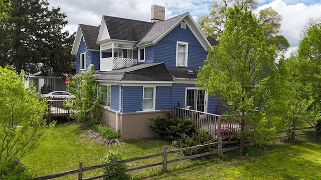 416 S Michigan Ave, Manton, MI 49663 - back of house with a shingled roof, a wooden deck, and a chimney