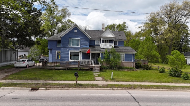 416 S Michigan Ave, Manton, MI 49663 - victorian home with a wooden deck, a chimney, and roof with shingles