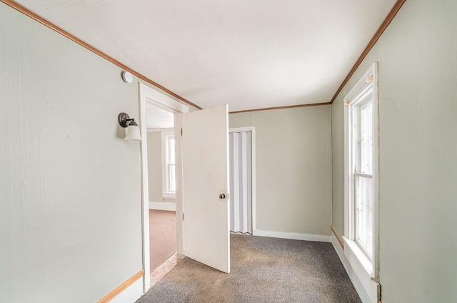 unfurnished room with light colored carpet, crown molding, and plenty of natural light