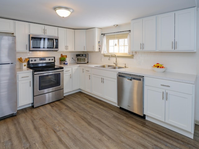 kitchen with sink, white cabinets, dark hardwood / wood-style floors, and appliances with stainless steel finishes