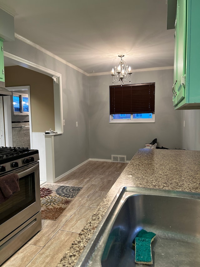 kitchen featuring ornamental molding, an inviting chandelier, stainless steel range with gas cooktop, and green cabinets