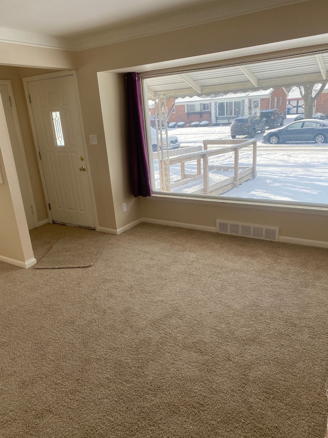 entryway with crown molding and carpet flooring