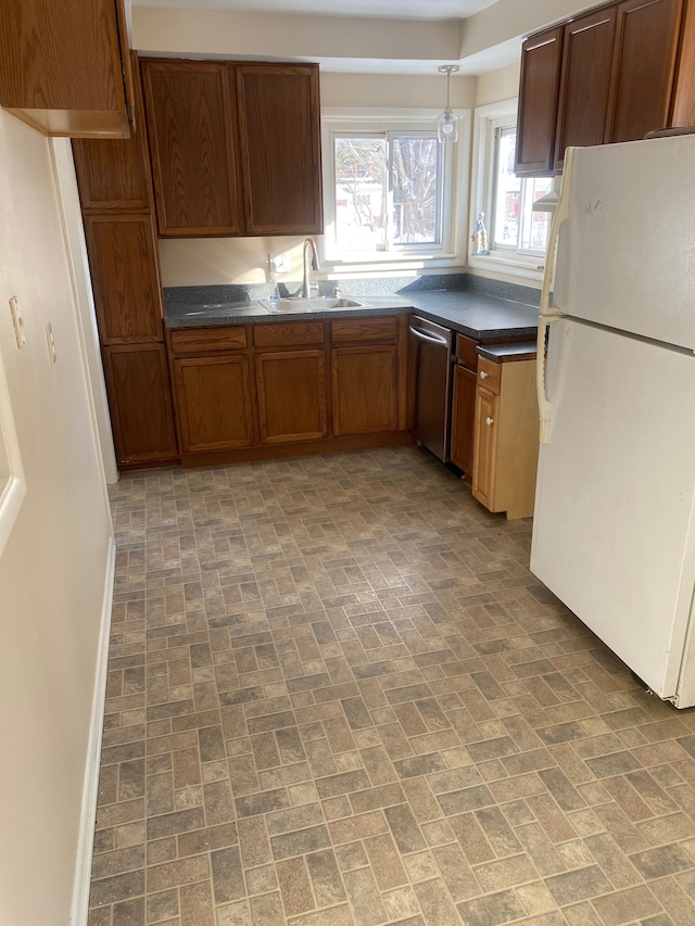 kitchen with stainless steel dishwasher, decorative light fixtures, sink, and white fridge