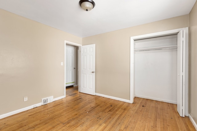 unfurnished bedroom featuring hardwood / wood-style floors and a closet