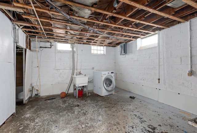 basement featuring sink, a healthy amount of sunlight, and washer and clothes dryer