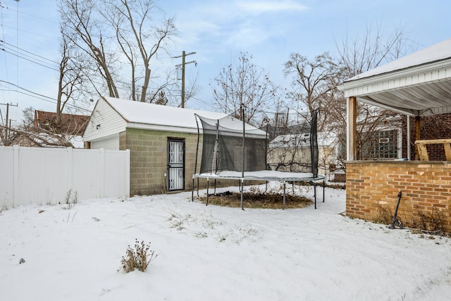 snowy yard with a trampoline