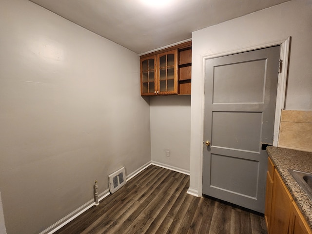 interior space with baseboards, visible vents, dark wood finished floors, and a sink