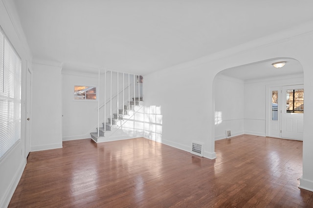 unfurnished living room with dark hardwood / wood-style floors and crown molding