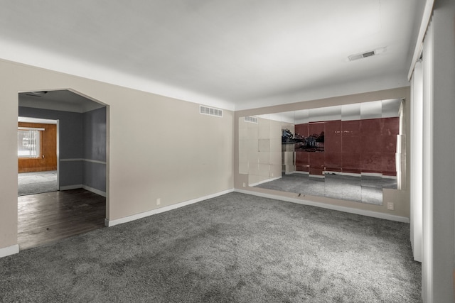 unfurnished living room with dark carpet