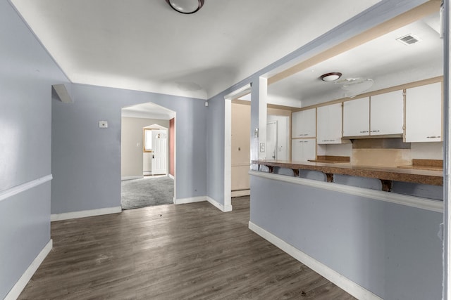 kitchen featuring dark hardwood / wood-style floors, white cabinets, and baseboard heating