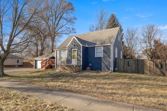 view of front of property featuring a front lawn and a storage shed