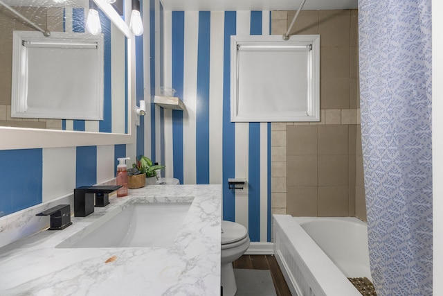 full bathroom featuring tiled shower / bath, vanity, and toilet