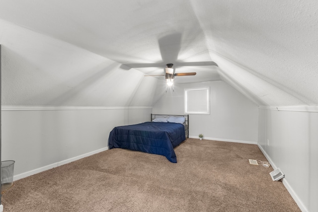 bedroom featuring ceiling fan, vaulted ceiling, a textured ceiling, and carpet flooring