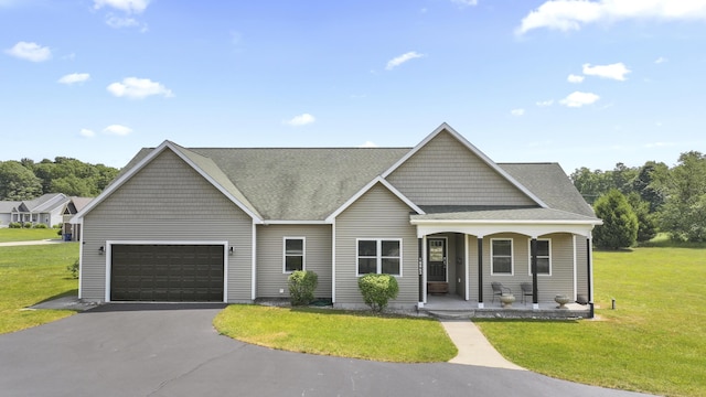 view of front facade with covered porch, a front lawn, and a garage