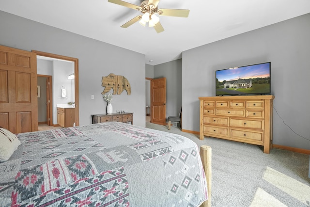 carpeted bedroom with ensuite bathroom and ceiling fan