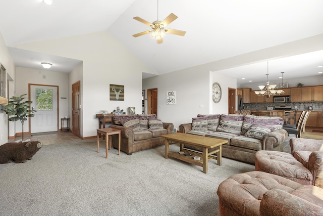 carpeted living room featuring ceiling fan with notable chandelier and high vaulted ceiling