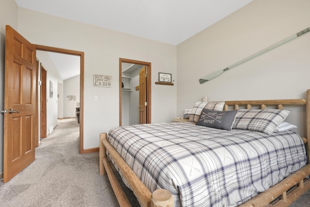 carpeted bedroom with a walk in closet and a closet