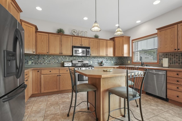 kitchen with stainless steel appliances, light tile patterned floors, pendant lighting, and a center island