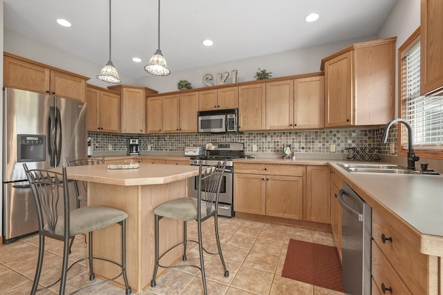 kitchen with a center island, decorative light fixtures, appliances with stainless steel finishes, light tile patterned flooring, and sink