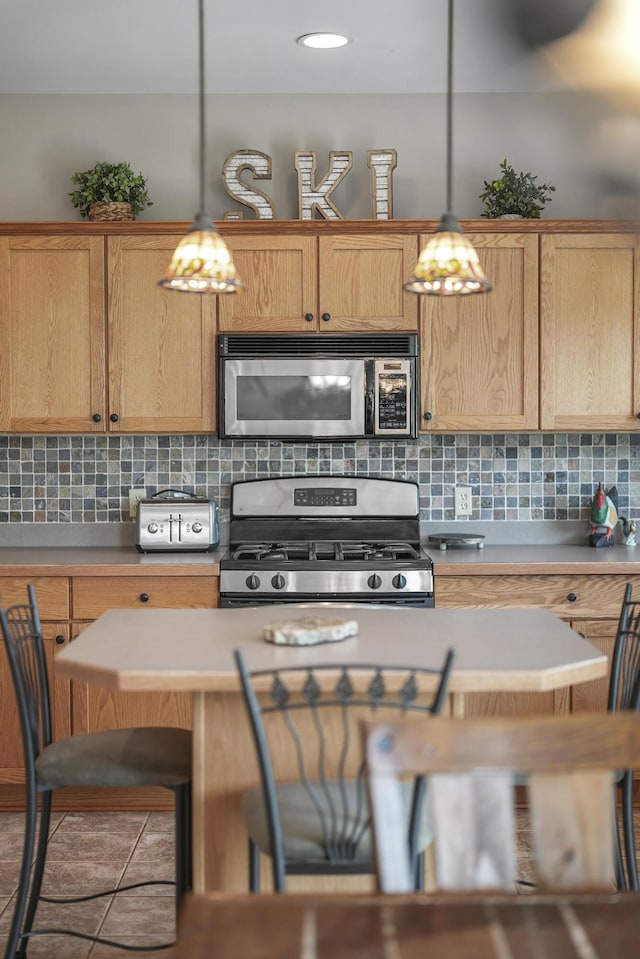 kitchen with decorative light fixtures, stainless steel appliances, and tasteful backsplash