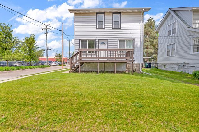 rear view of house featuring a lawn and a wooden deck