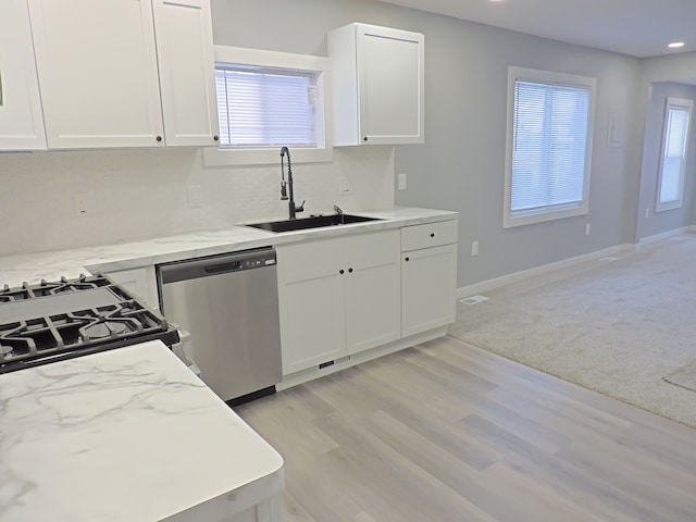 kitchen featuring sink, dishwasher, light stone counters, and white cabinets