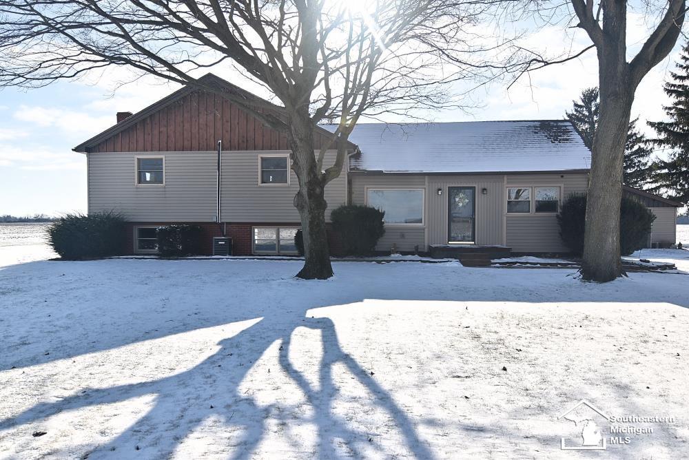 view of snow covered rear of property