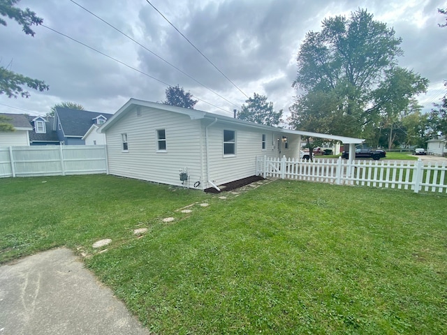 rear view of property featuring a yard and a carport