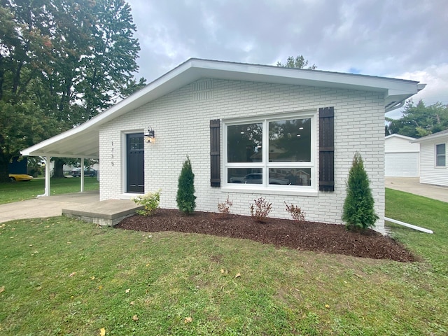 view of front of home with a carport and a front lawn