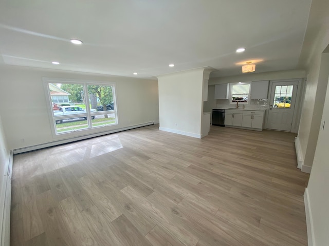 unfurnished living room featuring sink, a baseboard radiator, and light hardwood / wood-style floors