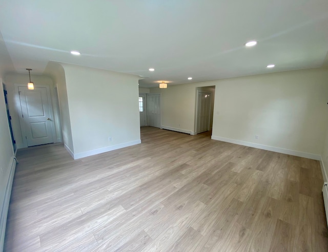 spare room with light wood-type flooring and a baseboard heating unit