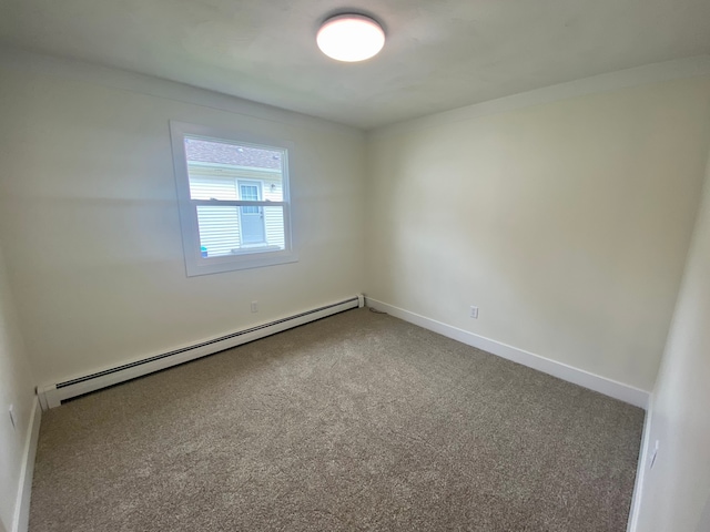 empty room with a baseboard heating unit and carpet