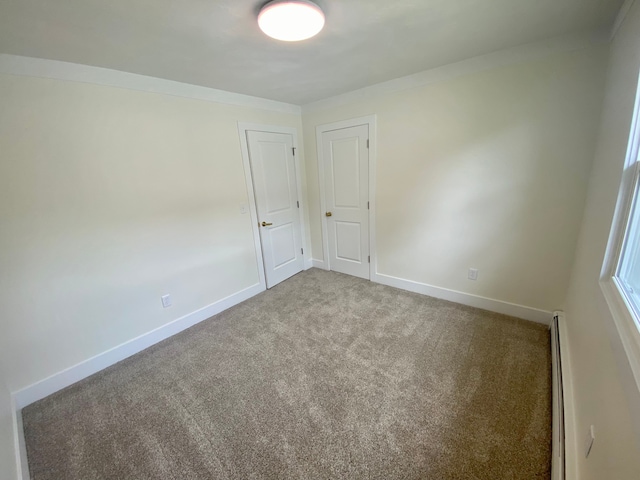 unfurnished room featuring a baseboard radiator and carpet