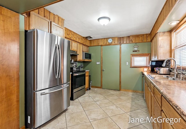 kitchen featuring stainless steel appliances, light tile patterned flooring, and sink