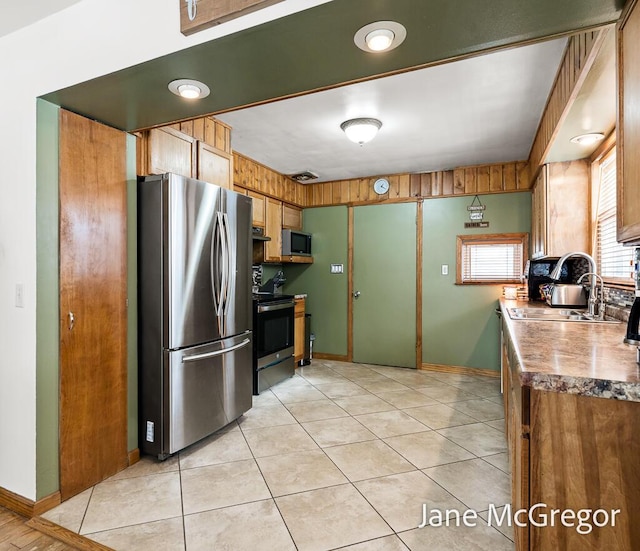 kitchen featuring appliances with stainless steel finishes, light tile patterned floors, and sink